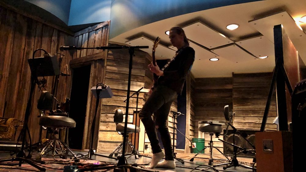 Niki Liljestrand Astia-studio A:n soittohuoneessa kitaraäänitykseen uppoutuneena