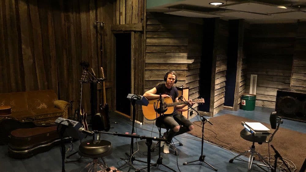 Niki Liljestrand soittamassa akustista kitaraa albumin avausraitaan